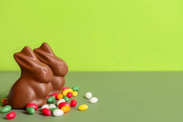 緑の背景にチョコレートイースターバニーとキャンディー — ストック写真