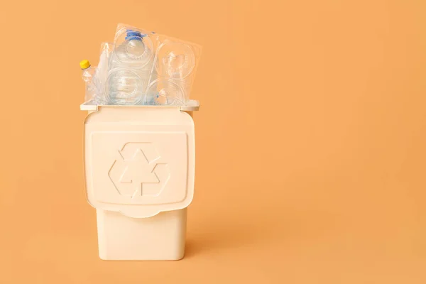 Container for garbage with plastic on beige background. Recycling concept