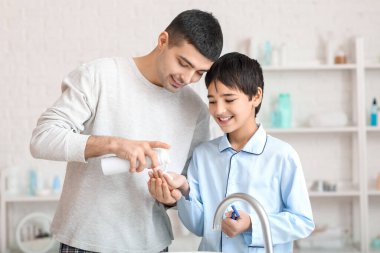 Morning of father and his little son shaving in bathroom