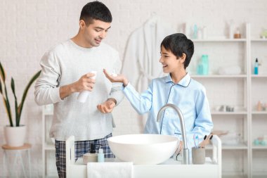 Morning of father and his little son shaving in bathroom