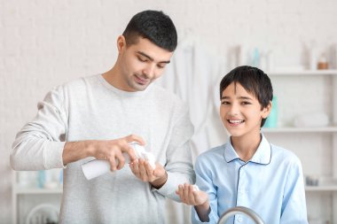 Morning of father and his little son shaving in bathroom