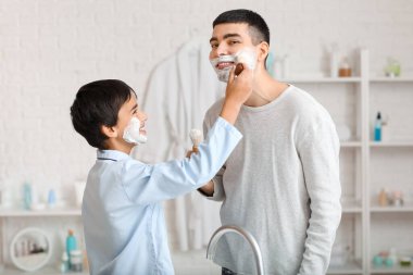 Morning of father and his little son shaving in bathroom