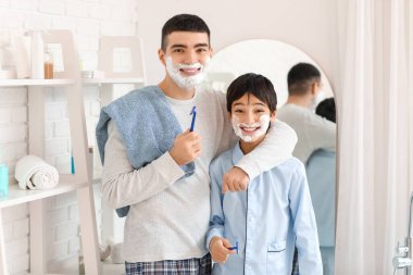 Morning of father and his little son shaving in bathroom