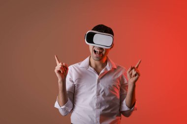 Genç adam arka planda VR gözlüğü kullanıyor