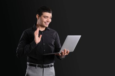 Bilgisayarlı iş danışmanı karanlık arka planda görüntülü sohbet ediyor.