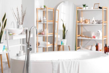 Banyonun içinde küvet, ayna ve raf üniteleri var.