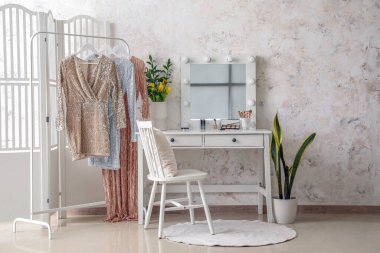 Soyunma odasının içinde ayna ve vazoda laleler var.