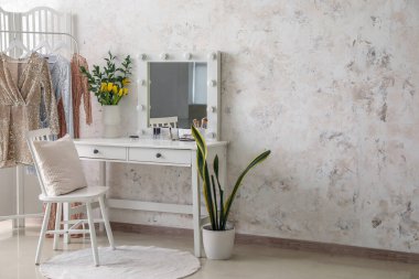 Soyunma odasının içinde ayna ve vazoda laleler var.