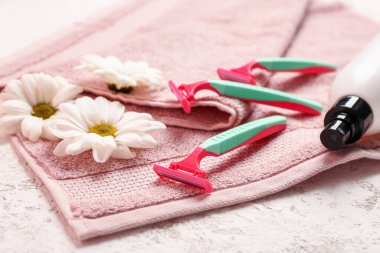 Güvenlik jiletleri, papatya çiçekleri ve beyaz grunge arka planda havlu.