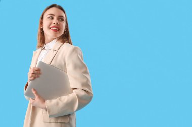 Mavi arka planda dizüstü bilgisayarı olan kadın programcı