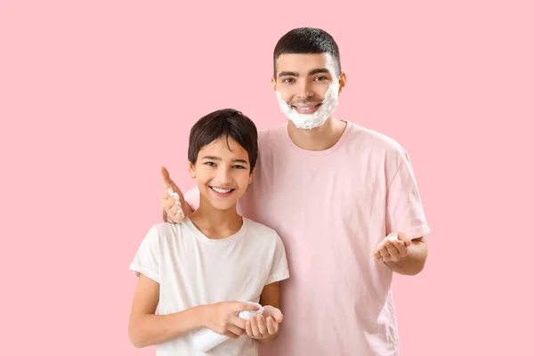 Man His Little Son Applying Shaving Foam Faces Pink Background — Stockfoto