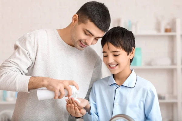 Morning of father and his little son shaving in bathroom