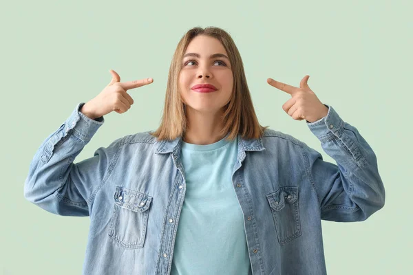 Ung Kvinna Denim Skjorta Pekar Hennes Ansikte Grön Bakgrund — Stockfoto