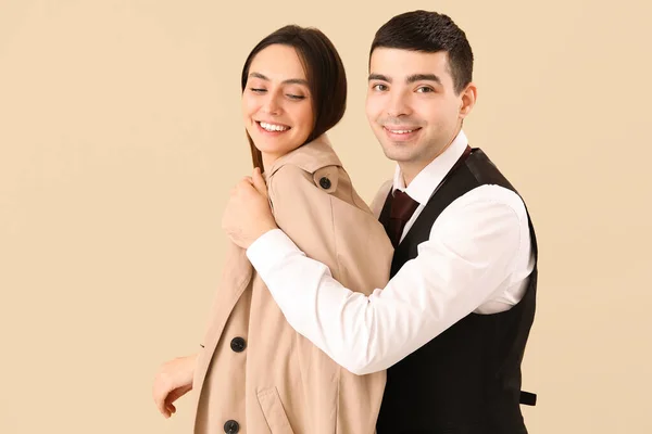 在他女朋友身上涂上米色背景外套的年轻人 — 图库照片