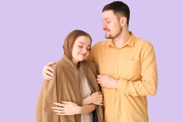 Young Man Hugging Wife His Jacket Lilac Background — Stock Photo, Image