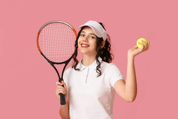 Teenage tennis player with racket and ball on pink background