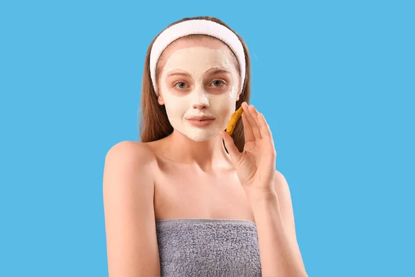 青の背景に適用されたターメリックマスクと根を持つ若い女性 クローズアップ — ストック写真