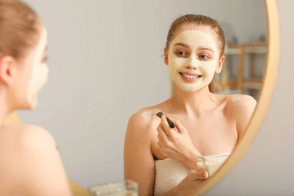 Young Woman Applying Turmeric Mask Brush Mirror Home — Stock Photo, Image