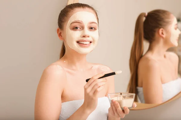 Wanita Muda Menerapkan Masker Kunyit Dengan Kuas Dekat Cermin Rumah — Stok Foto