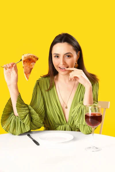 Νεαρή Γυναίκα Νόστιμη Πίτσα Και Ποτήρι Κρασί Στο Τραπέζι Κίτρινο — Φωτογραφία Αρχείου