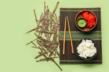 Pirinç, zencefil, wasabi ve yeşil arka planda Norveç çarşafları ile bambu hasırı.