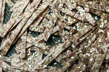 Kesik yapraklı bambu hasırı ve susam tohumları, yakın plan.