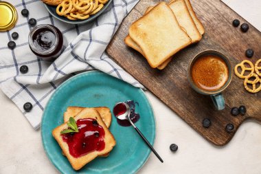 Yaban mersini reçelli lezzetli tostlar ve açık arkaplanda bir fincan kahve.