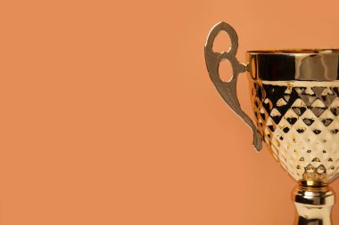 Turuncu arka planda altın kupa, yakın plan