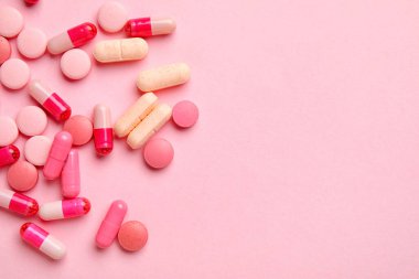 Pembe arka planda farklı haplar.