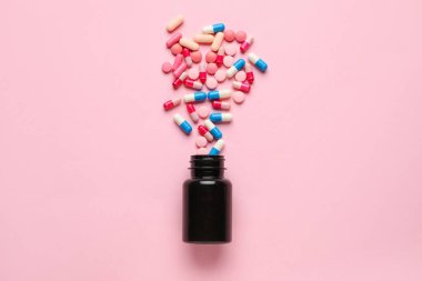 Pembe arka planda hapları olan şişe.