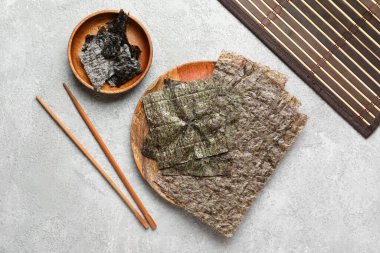 Açık arkaplanda Norveç çarşafları, yemek çubukları ve bambu paspası olan bir tabak.