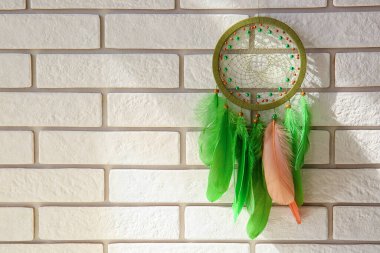 Beyaz tuğla duvarda asılı rüya yakalayıcı