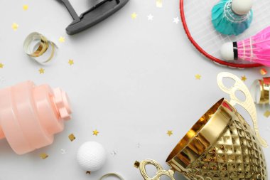 Spor ekipmanları ve hafif arka planda konfetileri olan altın bardaktan yapılmış çerçeve