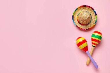 Pembe arka planda sombrero şapkalı Meksika marakaları