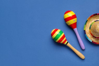 Mavi arka planda şapkası olan Meksika marakaları