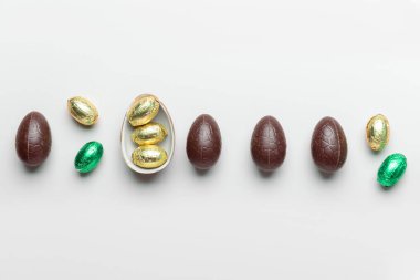 Tatlı çikolatalı Paskalya yumurtaları ve hafif arka planda şekerler