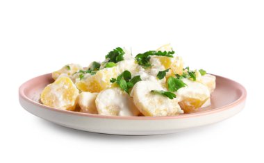 Beyaz arka planda yeşil salatalı lezzetli patates salatası.