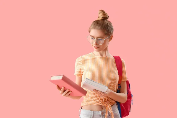 女性学生とともに本やバックパックでピンクの背景 — ストック写真