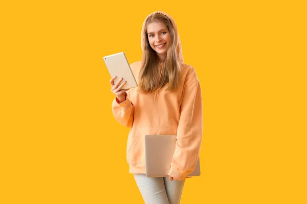 Programmiererin Mit Tablet Computer Und Laptop Auf Gelbem Hintergrund — Stockfoto
