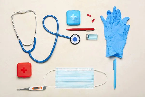 Frame made of stethoscope, thermometer, medical mask, gloves and medicines on light background. Melanoma concept