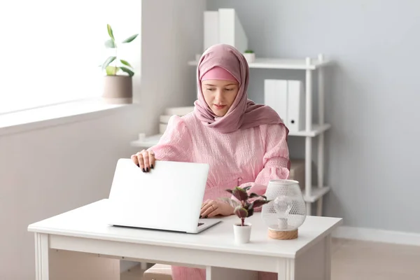 stock image Muslim female programmer working with laptop at table in office