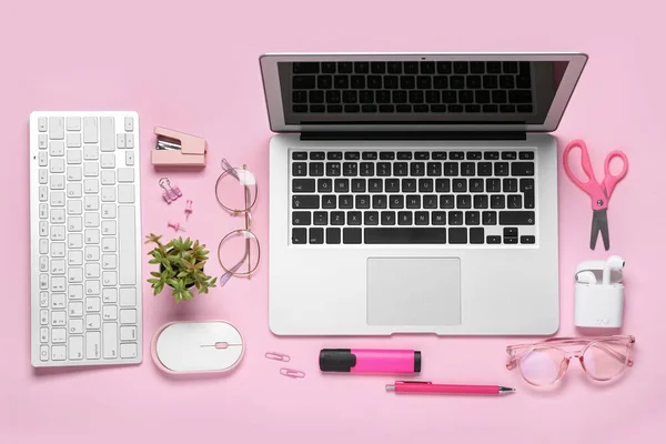 Composition with laptop, eyeglasses and stationery on pink background