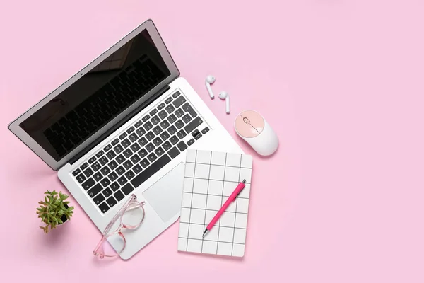 Composition with laptop, eyeglasses and notepad on pink background