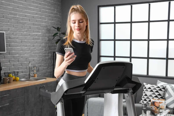 Sporty Young Woman Using Mobile Phone Treadmill Home — Stock Photo, Image