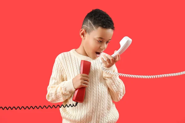 Маленький Афроамериканец Двумя Телефонными Приемниками Красном Фоне — стоковое фото