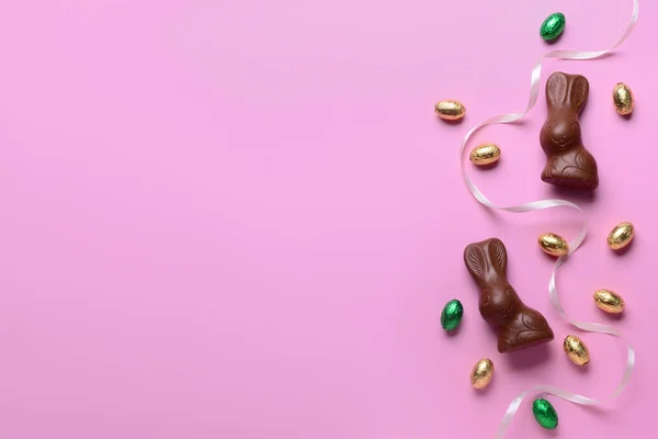 チョコレートバニー イースターエッグとピンクの背景にリボン — ストック写真