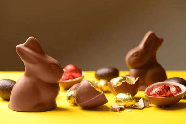 Čokoládová Velikonoční Vajíčka Zajíčci Žlutém Stole Hnědém Pozadí — Stock fotografie
