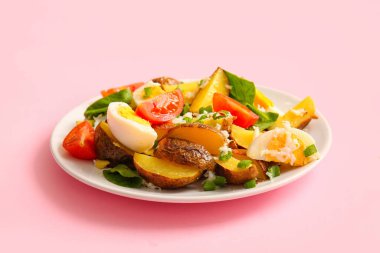 Pembe arka planda bir tabak lezzetli patates salatası
