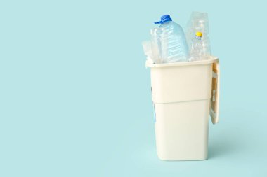 Açık mavi arka planda plastik olan çöp konteynırı. Geri dönüşüm kavramı