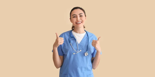 Female Medical Assistant Showing Thumb Beige Background — Stock Photo, Image
